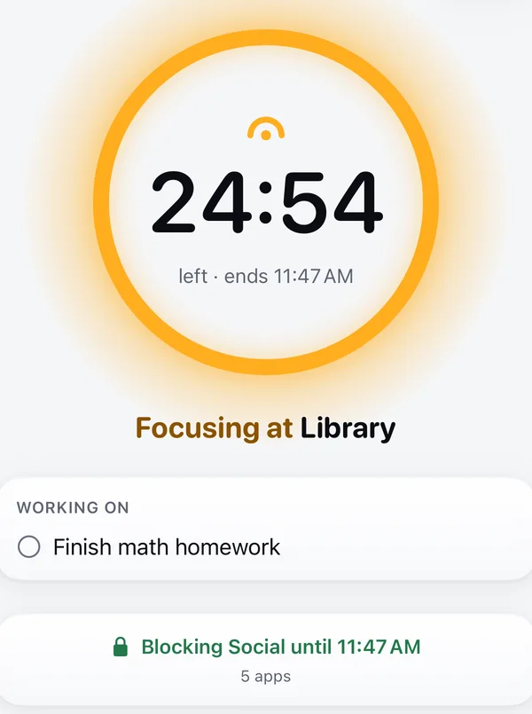 The Focus screen: 24:54 left in an amber ring, focusing at Library on Finish math homework, blocking Social (5 apps) until 11:47 AM.